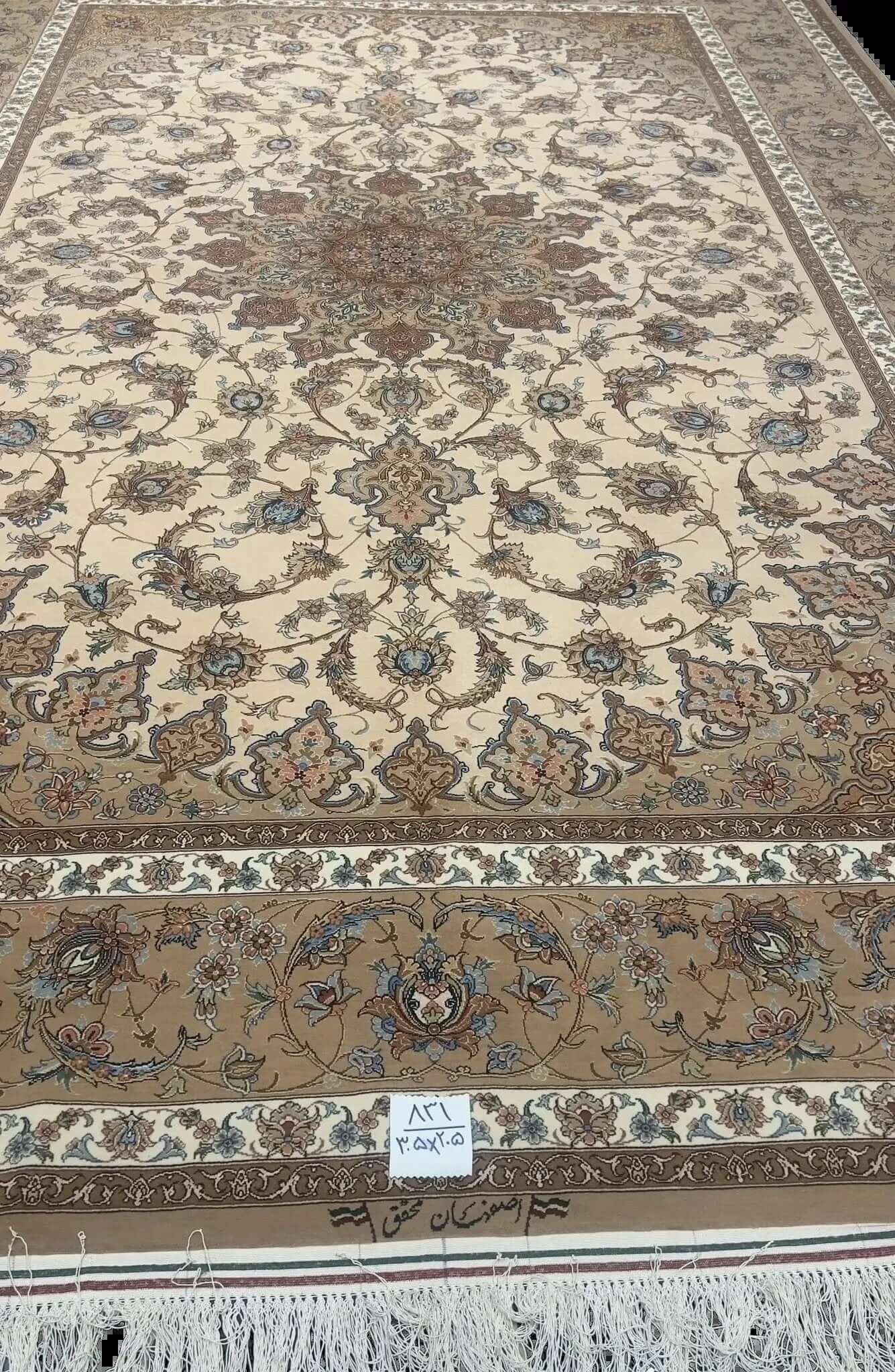 Hand-Knotted Persian Rug by Mohaghegh – 305x205 cm: This hand-knotted Persian rug from Isfahan, featuring a blend of wool and silk in elegant brown and beige tones, is perfect for elevating home interiors. Crafted by master weaver Mohaghegh, it offers luxurious quality and timeless design.